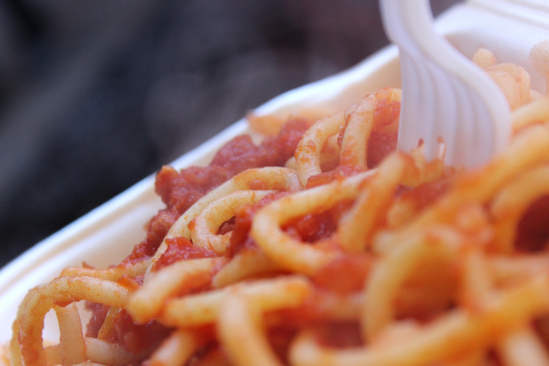 Close-up to Amatriciana spaghetti with a plastic fork